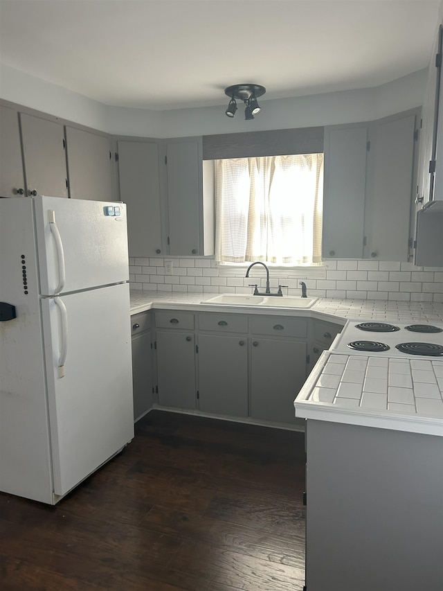 kitchen featuring sink, white refrigerator, backsplash, and dark hardwood / wood-style floors