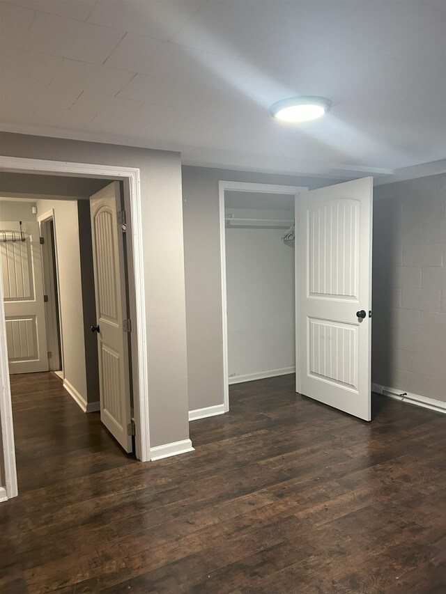 unfurnished bedroom featuring a closet and dark wood-type flooring