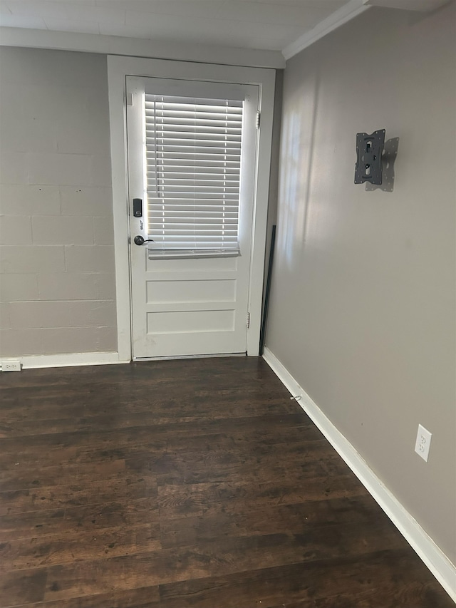 doorway with dark wood-type flooring and crown molding