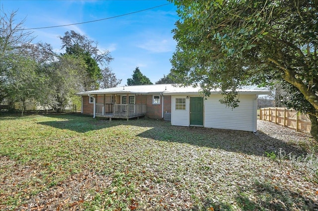 rear view of property featuring a deck and a lawn