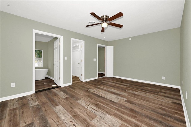 unfurnished bedroom with dark hardwood / wood-style flooring, ensuite bathroom, ceiling fan, a spacious closet, and a closet