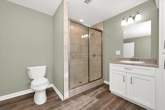 bathroom with hardwood / wood-style flooring, vanity, toilet, and an enclosed shower