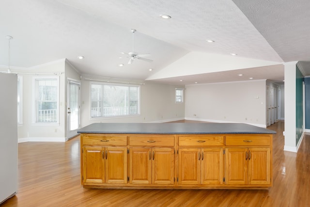 kitchen with vaulted ceiling, a textured ceiling, light wood-type flooring, stainless steel refrigerator, and ceiling fan