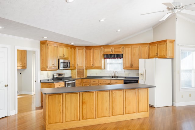 kitchen with lofted ceiling, stainless steel appliances, tasteful backsplash, a kitchen island, and light wood-type flooring