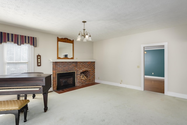 miscellaneous room with a brick fireplace, a textured ceiling, a chandelier, and carpet flooring