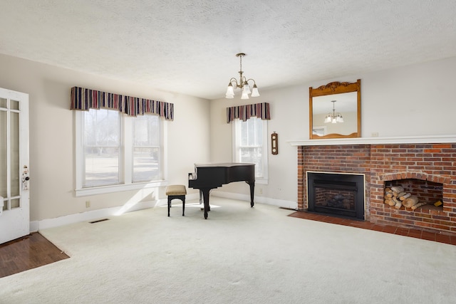 interior space featuring carpet flooring, a textured ceiling, a brick fireplace, and a notable chandelier