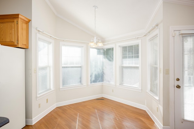 unfurnished dining area featuring ornamental molding, lofted ceiling, a chandelier, and light hardwood / wood-style flooring