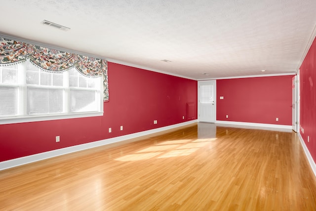 unfurnished room featuring hardwood / wood-style floors, ornamental molding, and a textured ceiling