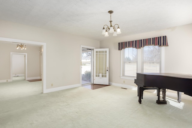 misc room featuring a healthy amount of sunlight, light colored carpet, a textured ceiling, and an inviting chandelier