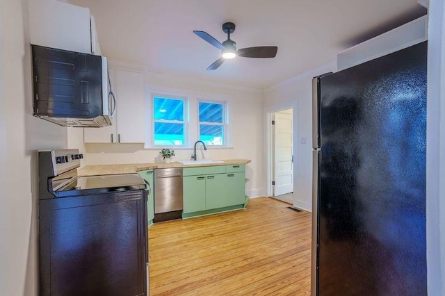 kitchen featuring sink, ceiling fan, green cabinets, stainless steel appliances, and light hardwood / wood-style floors