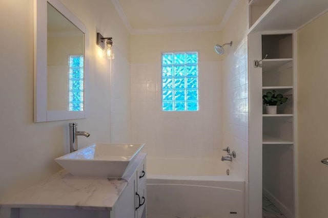 bathroom with tiled shower / bath combo, vanity, and ornamental molding