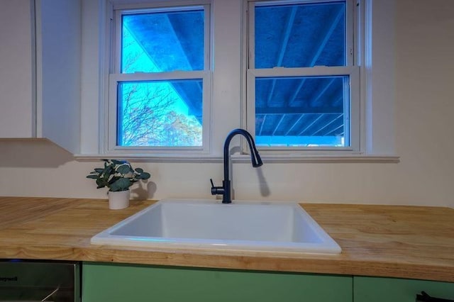 room details with green cabinetry, wooden counters, and sink