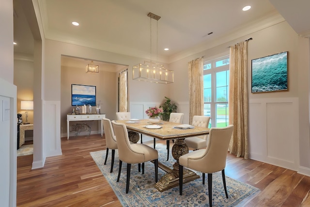  - dining space featuring a decorative wall, wood finished floors, ornamental molding, a wainscoted wall, and recessed lighting