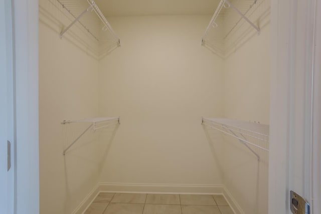  - walk in closet with light tile patterned flooring