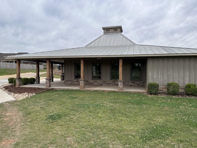  - back of house with a lawn, board and batten siding, a metal roof, and a porch