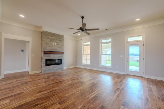  - unfurnished living room with crown molding, wood finished floors, a ceiling fan, a fireplace, and recessed lighting