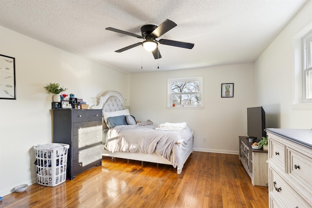 bedroom with a textured ceiling, hardwood / wood-style flooring, and ceiling fan