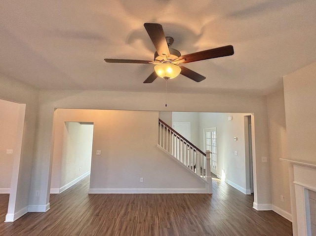 unfurnished living room featuring ceiling fan and dark wood-type flooring