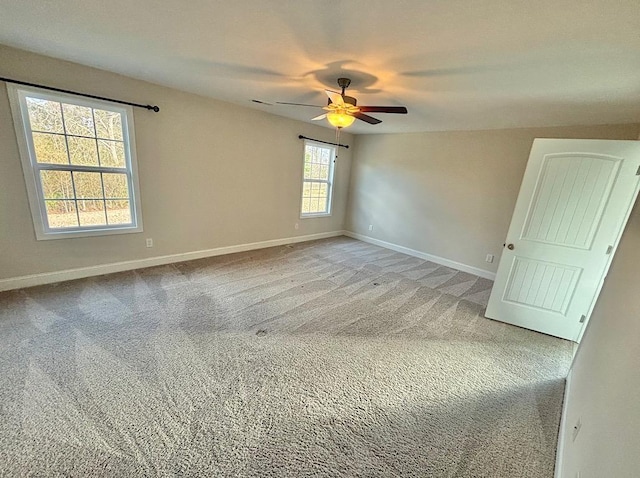 empty room with ceiling fan and light carpet