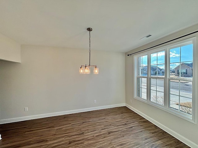 unfurnished dining area featuring a notable chandelier and dark hardwood / wood-style floors