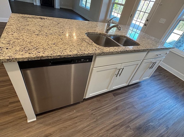 kitchen with sink, white cabinets, dishwasher, light stone countertops, and dark hardwood / wood-style floors