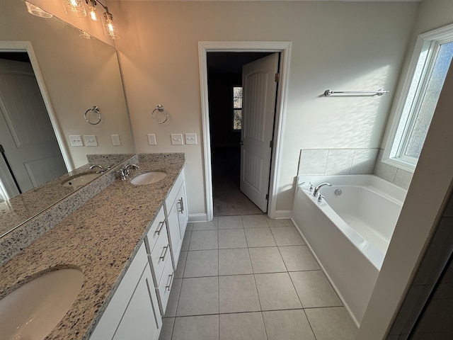 bathroom with vanity, a tub, a wealth of natural light, and tile patterned floors