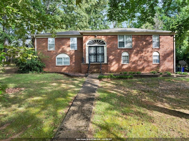  - view of front facade with brick siding and a front yard