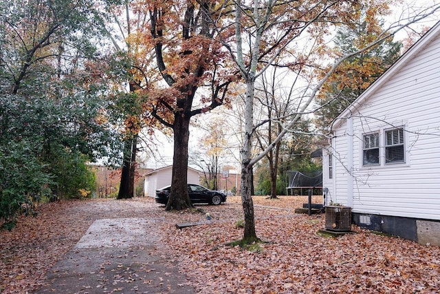 view of yard with central AC and a trampoline