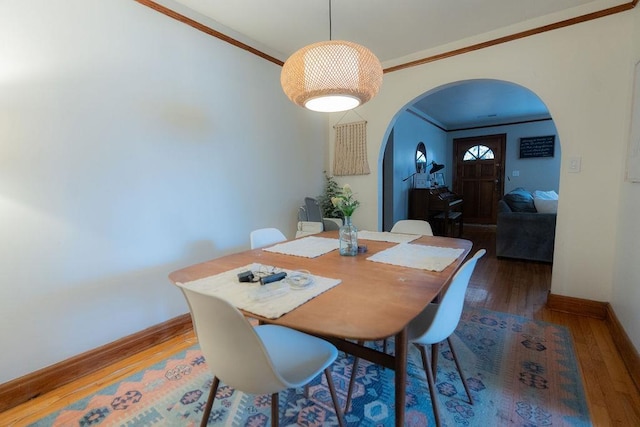 dining area featuring crown molding and dark wood-type flooring