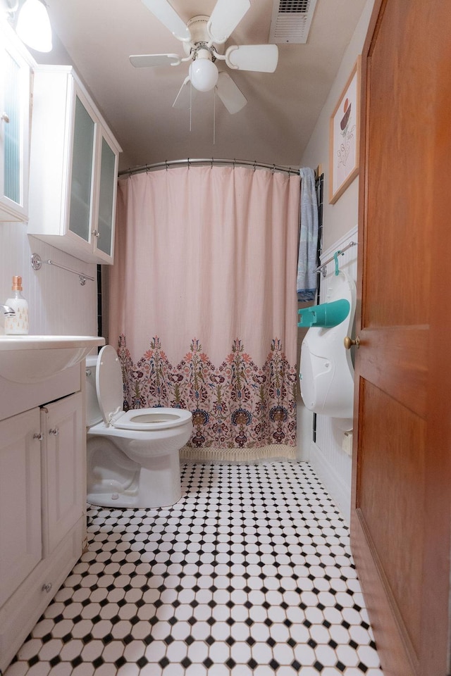 bathroom with a shower with curtain, ceiling fan, vanity, and toilet