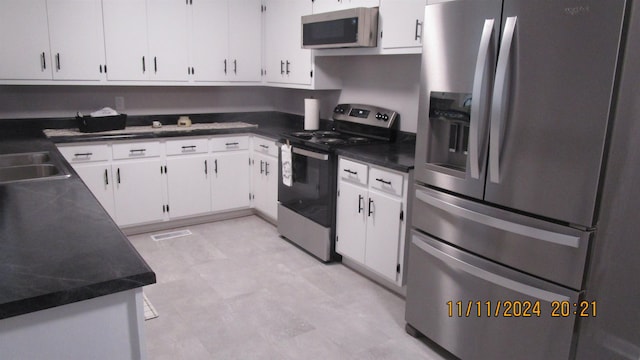 kitchen featuring appliances with stainless steel finishes, white cabinetry, and sink