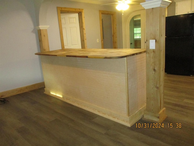 bar with dark hardwood / wood-style flooring, ceiling fan, and black fridge