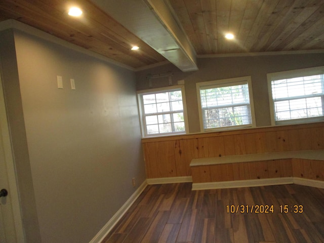 interior space featuring wooden ceiling, dark hardwood / wood-style floors, crown molding, lofted ceiling, and wooden walls