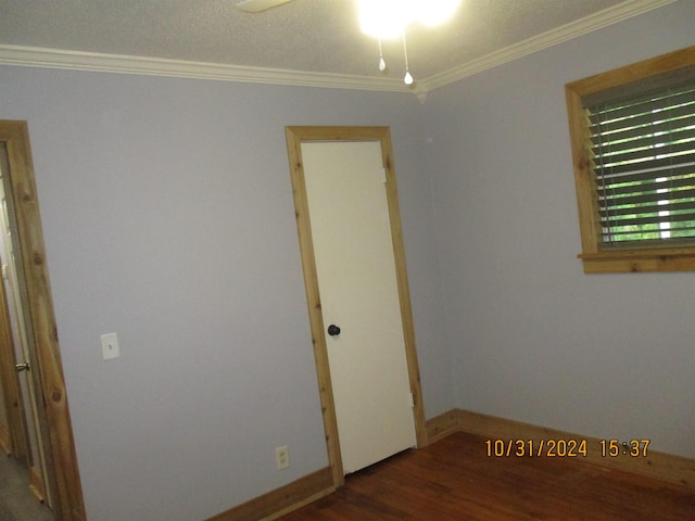 spare room with dark wood-type flooring, ceiling fan, and crown molding