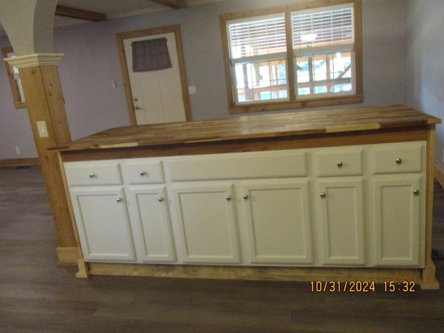 kitchen featuring white cabinets, decorative columns, and wooden counters