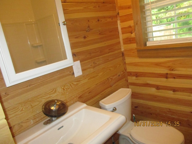 bathroom featuring wooden walls and sink