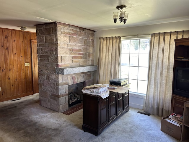 office space with carpet flooring, wooden walls, a fireplace, and ornamental molding