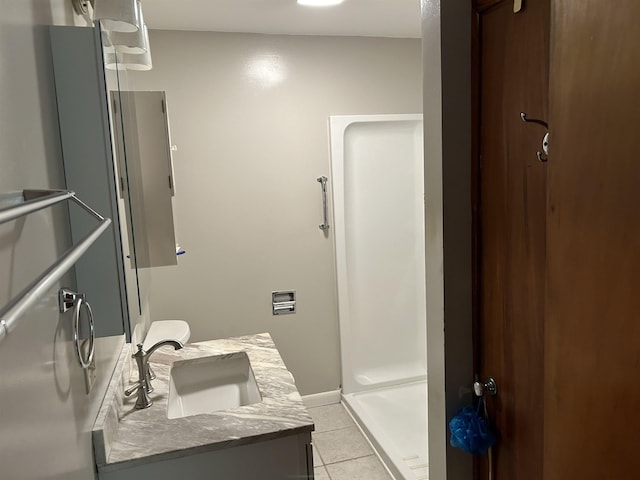 bathroom with tile patterned flooring, vanity, and walk in shower