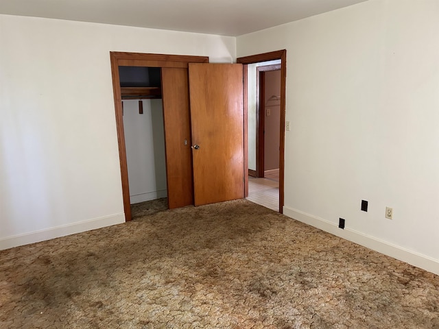 unfurnished bedroom featuring carpet flooring and a closet