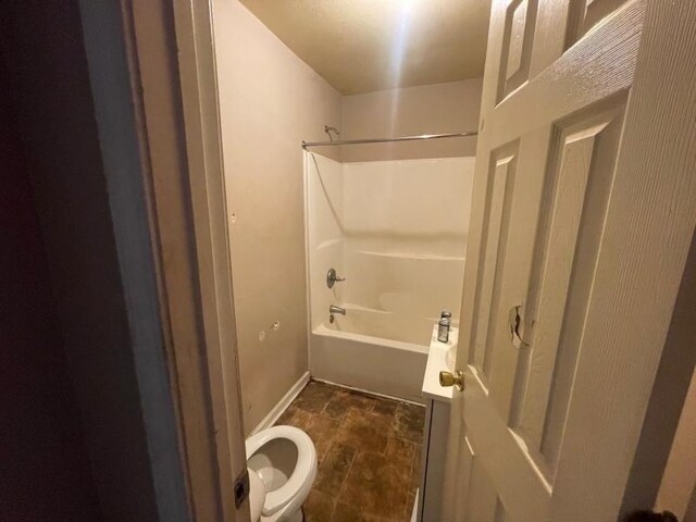  - full bathroom featuring stone finish flooring and shower / tub combination
