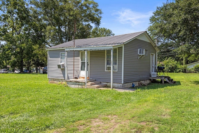  - view of front of property with a front lawn, metal roof, cooling unit, and a porch