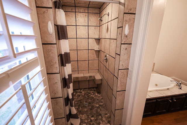 full bathroom with a jetted tub, a tile shower, and a wealth of natural light