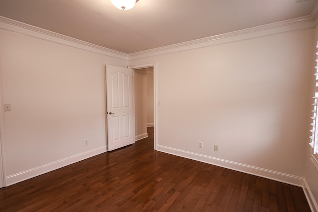 empty room with ornamental molding, dark wood-style flooring, and baseboards