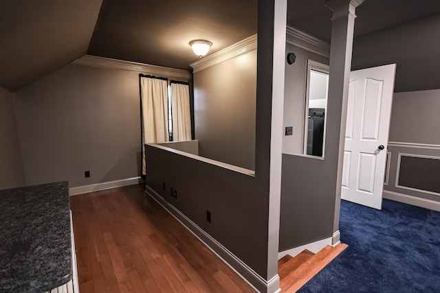 hall featuring decorative columns, baseboards, lofted ceiling, dark wood-style floors, and ornamental molding