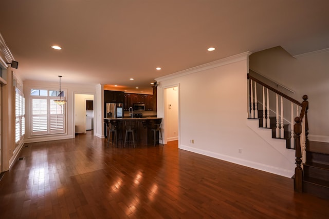 unfurnished living room with baseboards, dark wood-style floors, ornamental molding, stairs, and recessed lighting