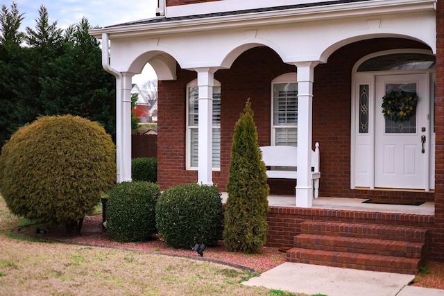 view of exterior entry with brick siding