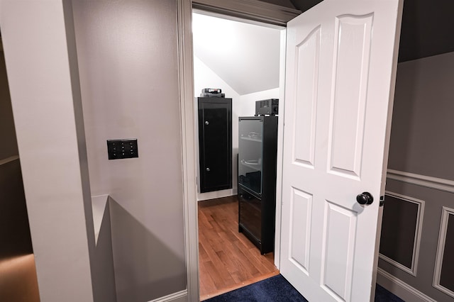 hallway featuring lofted ceiling and wood finished floors