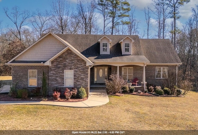 view of front of home featuring brick siding, a porch, and a front yard