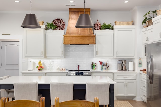 kitchen with stainless steel refrigerator with ice dispenser, premium range hood, decorative light fixtures, and white cabinets