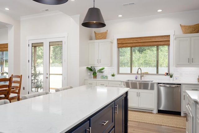 kitchen with white cabinetry, stainless steel dishwasher, and pendant lighting